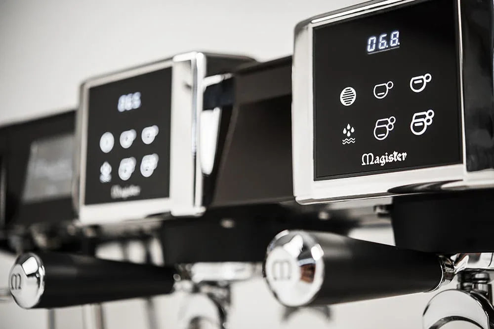Close-up van Magister espressomachine met touchscreen display en portafilters in moderne koffiebar